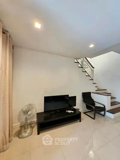 Modern living room with sleek staircase and minimalist decor
