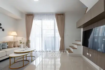 Modern living room with sleek design, large TV, and elegant furniture, perfect for relaxation and entertainment.