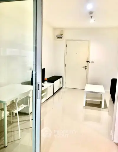 Modern living room with sleek furniture and glossy flooring in a bright apartment.