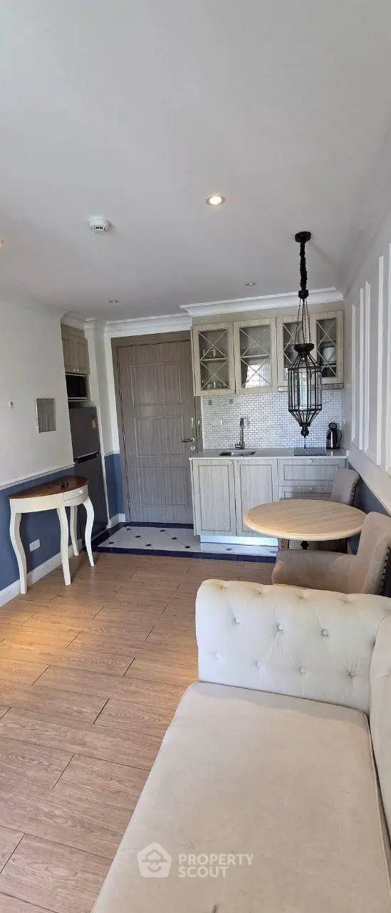 Charming open-layout living room with cozy seating and elegant kitchen area