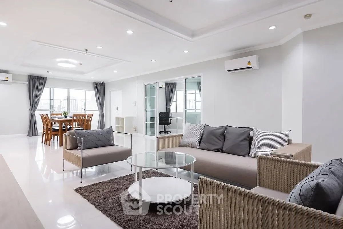 Spacious modern living room with elegant dining area and stylish furniture in open layout.
