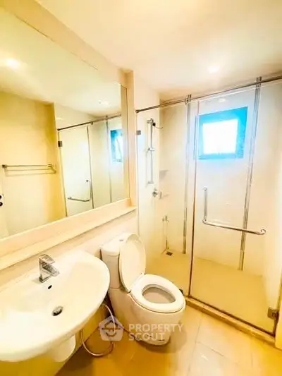 Modern bathroom with glass shower and sleek fixtures in a bright, elegant setting.