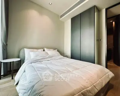Modern bedroom with sleek design and cozy bedding in a stylish apartment.