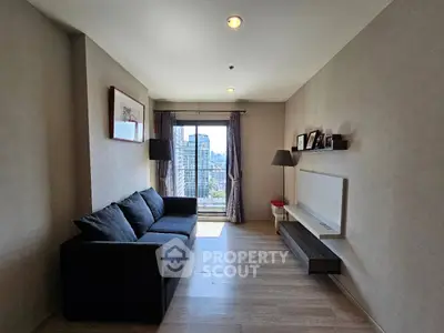 Modern living room with city view, featuring sleek furniture and natural light.