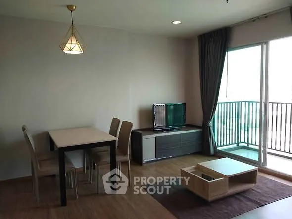 Modern living room with dining area and balcony access in a stylish apartment.
