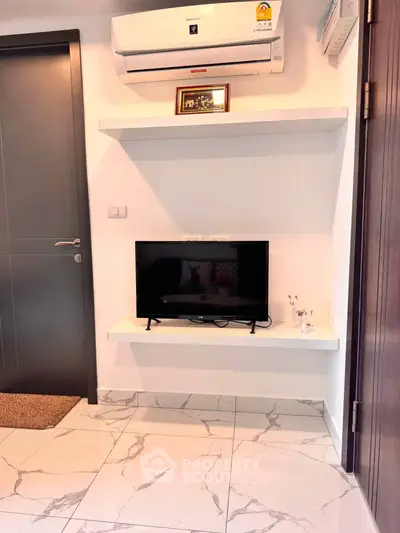 Modern living room corner with sleek TV setup and air conditioning unit.