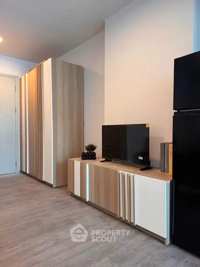 Modern living room with sleek wooden furniture and flat-screen TV, perfect for contemporary living.