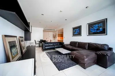 Spacious modern living room with sleek leather sofas and elegant decor.