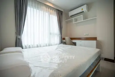 Modern bedroom with large window, air conditioning, and study desk in a stylish apartment.