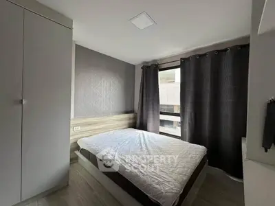 Modern bedroom with large window and stylish decor in a contemporary apartment.