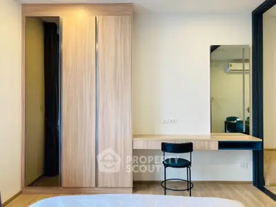 Modern bedroom with sleek wooden wardrobe and minimalist desk setup.