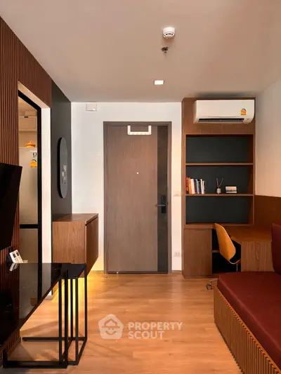 Modern apartment interior with stylish wooden accents and built-in shelving, featuring a cozy workspace and air conditioning.