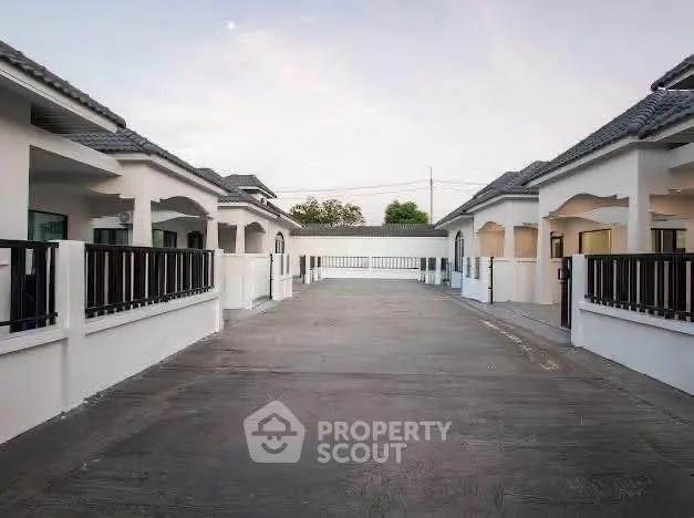 Charming residential complex with modern villas and spacious driveway.