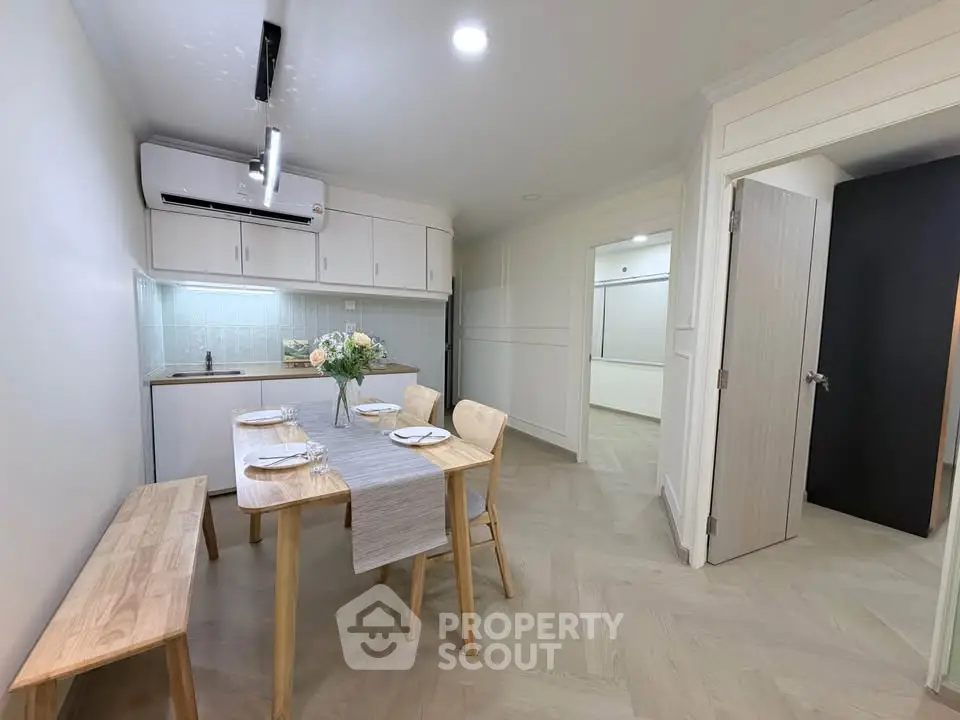 Modern dining area with minimalist decor and compact kitchen setup