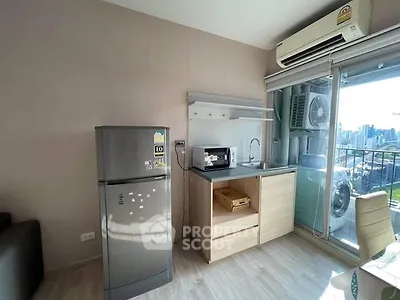 Modern compact kitchen with city view, featuring fridge, microwave, and air conditioning.
