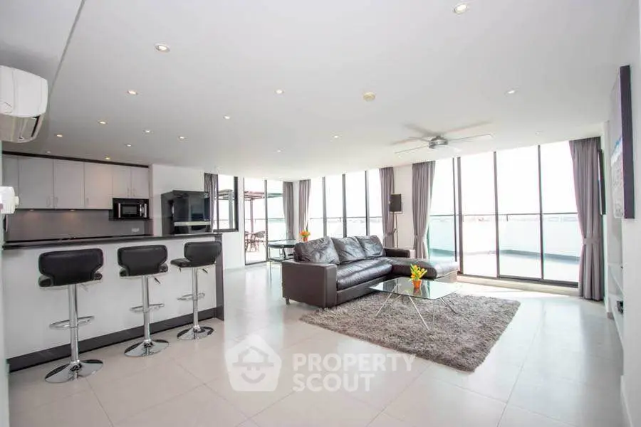 Spacious modern living room with open kitchen and stunning balcony view