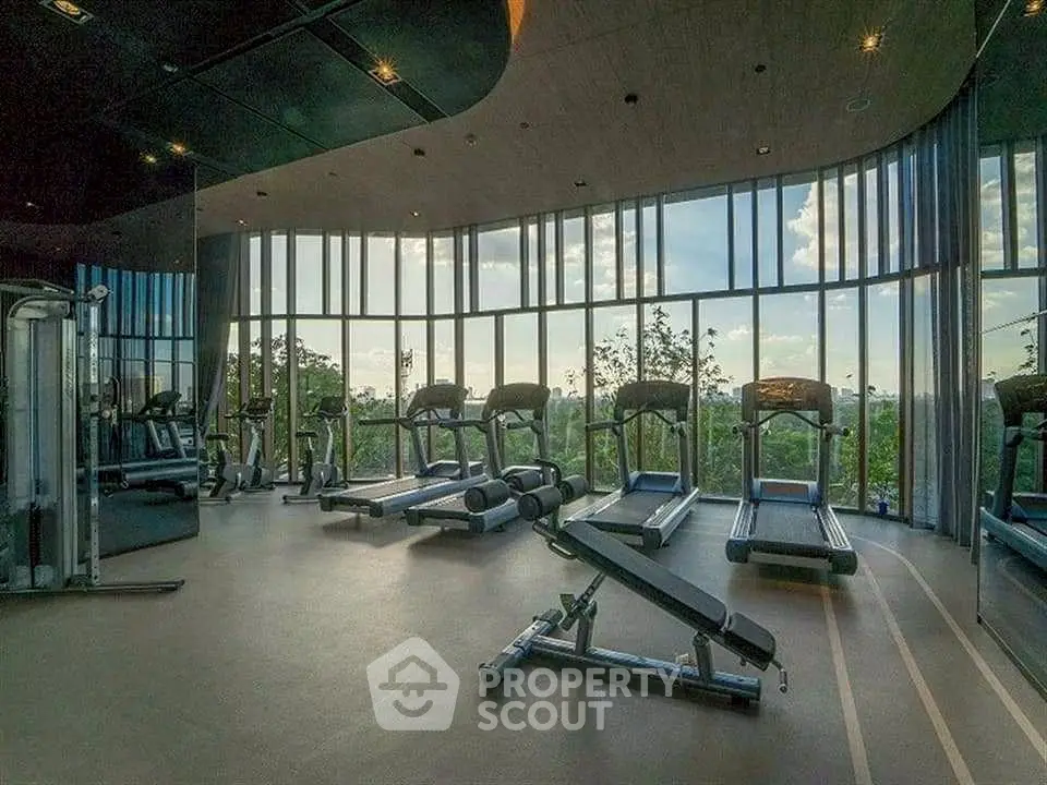 Luxurious gym with panoramic windows and modern equipment in a high-end residential complex.