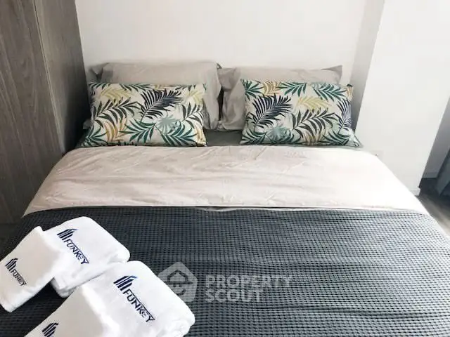 Cozy bedroom with stylish bedding and decorative pillows in modern apartment.