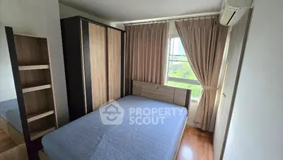 Cozy bedroom with large window and modern furnishings, perfect for relaxation and comfort.