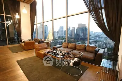 Luxurious living room with panoramic city view and elegant leather furniture.
