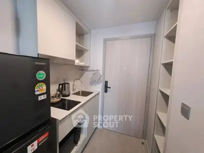 Compact modern kitchen with sleek appliances and ample storage in a cozy apartment.