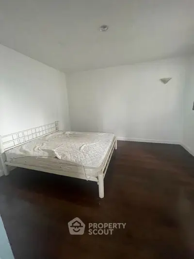 Spacious bedroom with minimalist design and wooden flooring