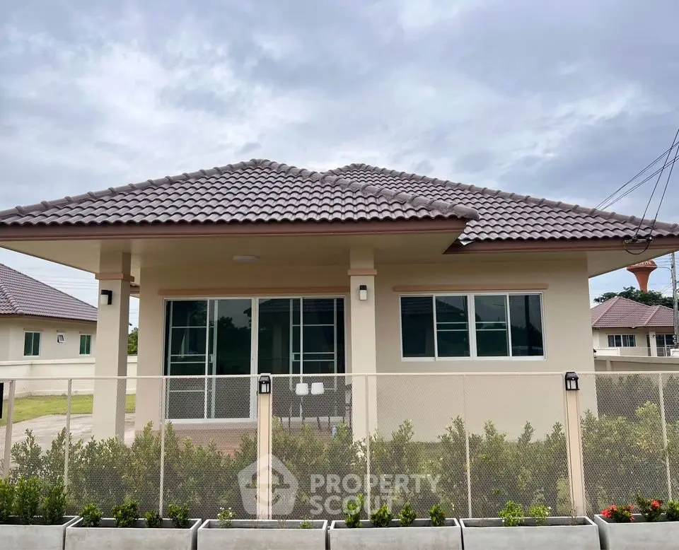 Charming single-story house with modern roof and lush garden, perfect for family living.