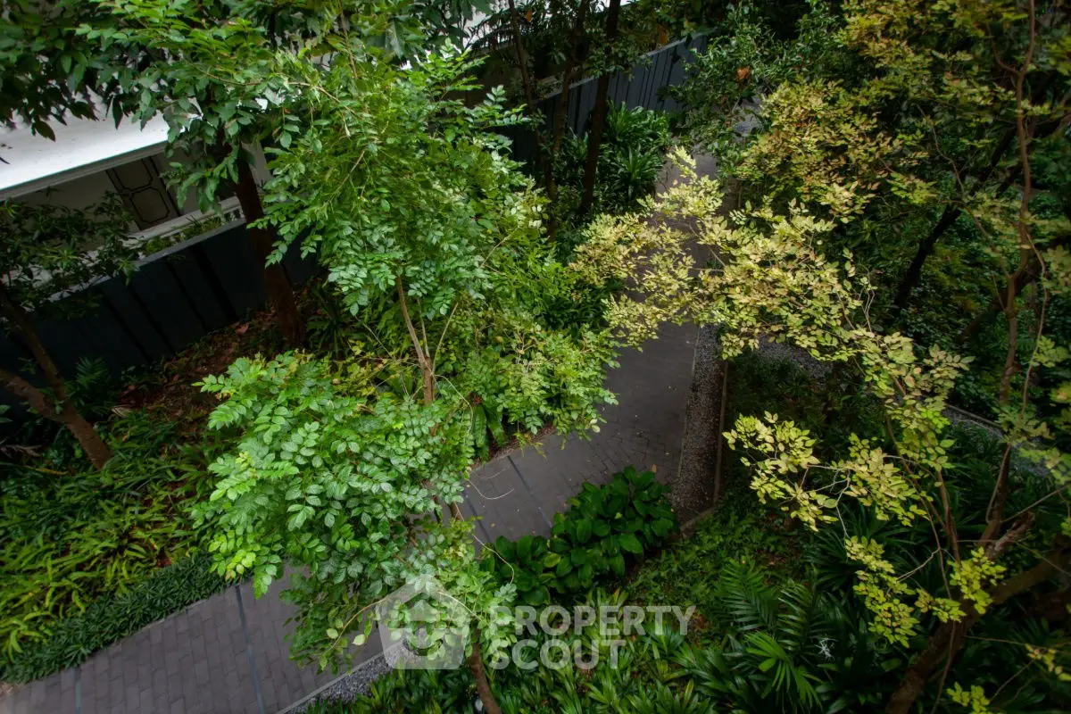 Lush garden path surrounded by vibrant greenery in a modern residential complex.