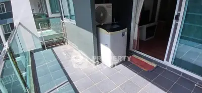 Spacious balcony with modern glass railing and outdoor air conditioning unit.