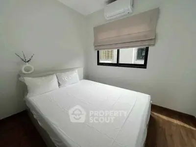 Cozy bedroom with natural light and modern air conditioning unit.