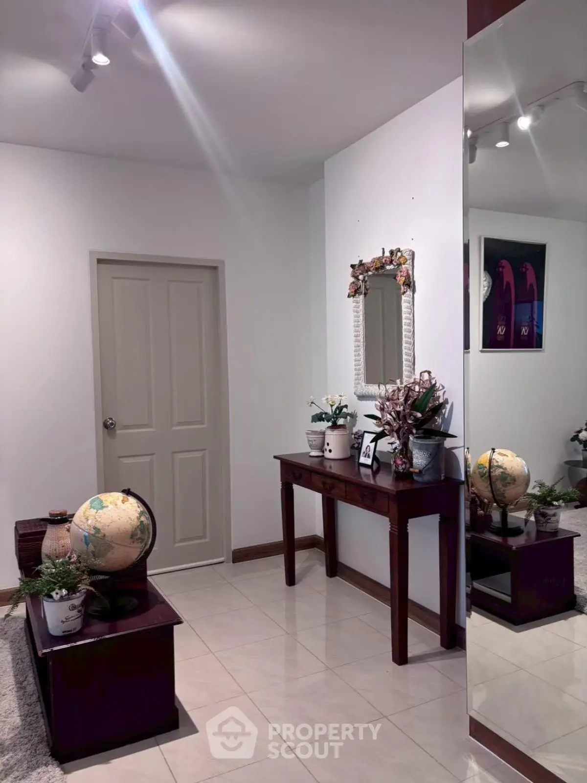 Elegant entryway with stylish decor and mirror reflecting a cozy ambiance.