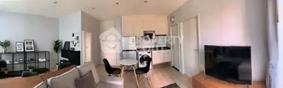 Modern open-plan living room with stylish kitchen and cozy seating area.