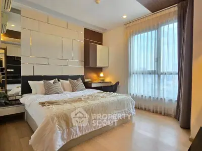 Luxurious bedroom with modern decor and large window offering natural light.