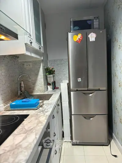 Modern kitchen with sleek appliances and marble countertops in cozy layout.