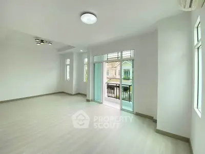 Spacious living room with large windows and balcony access in modern apartment.