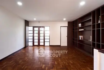 Spacious living room with wooden flooring and built-in shelves, perfect for modern living.