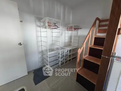 Spacious storage room with modern shelving and wooden staircase, perfect for organizing and maximizing space.