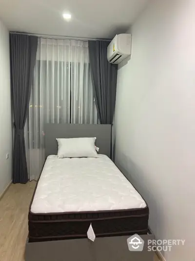 Cozy minimalist bedroom with single bed and air conditioning