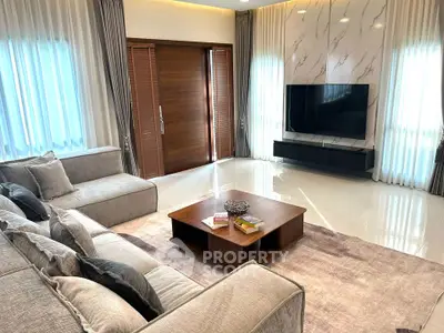 Luxurious living room with modern decor, large sofa, and flat-screen TV, perfect for relaxation and entertainment.