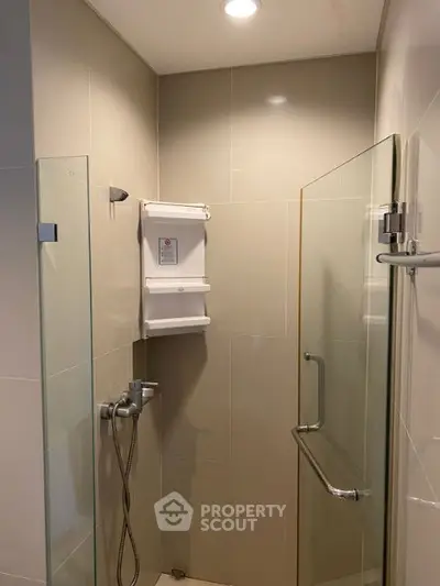 Modern bathroom shower area with glass doors and sleek fixtures