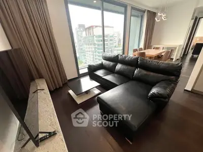 Modern living room with black leather sofa and city view