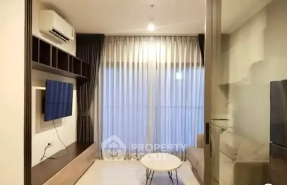 Modern living room with sleek furniture and large window, perfect for urban living.
