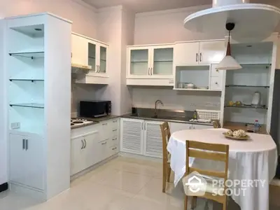 Bright and inviting kitchen with white cabinetry, modern appliances, and a cozy dining area perfect for intimate family meals.