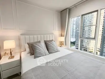 Modern bedroom with large windows offering city view in high-rise apartment