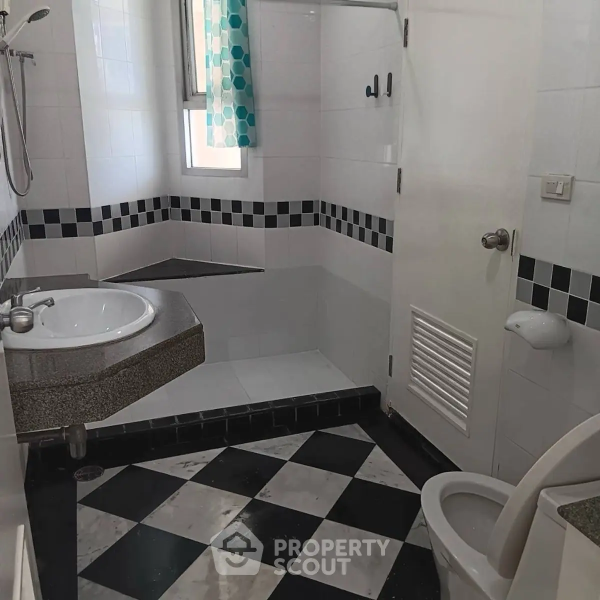 Modern bathroom with checkered floor and sleek fixtures in a stylish home.