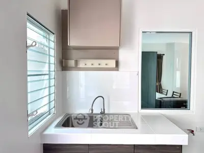 Modern kitchen with sleek sink and window, perfect for culinary creativity.