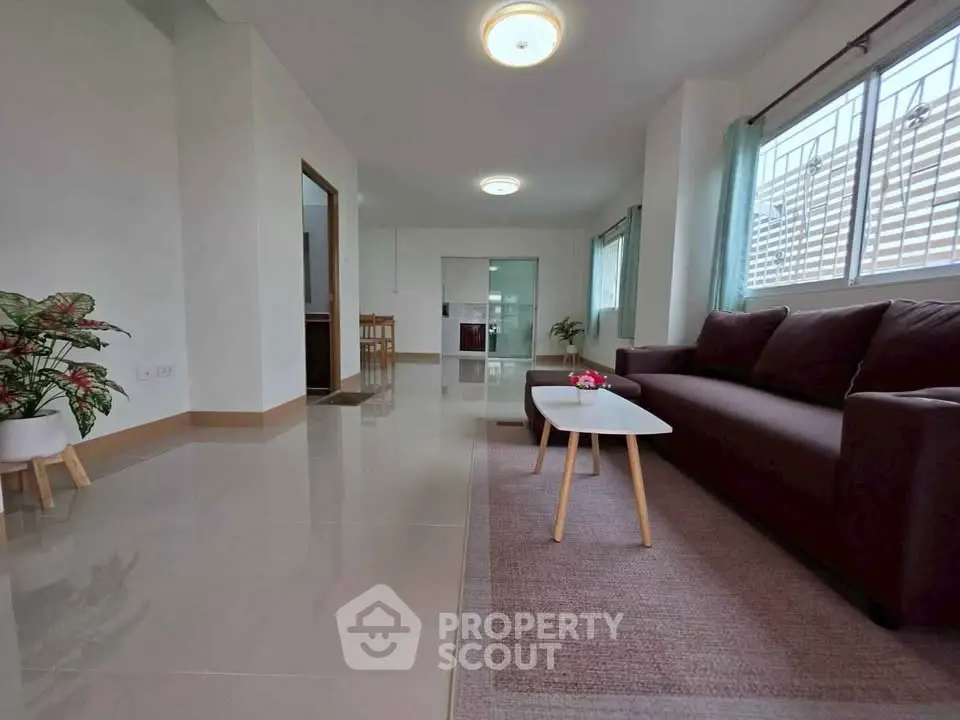Spacious modern living room with sleek furniture and large windows for natural light.