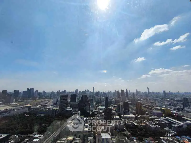 Stunning panoramic city view from a high-rise building, showcasing urban skyline under a clear blue sky.