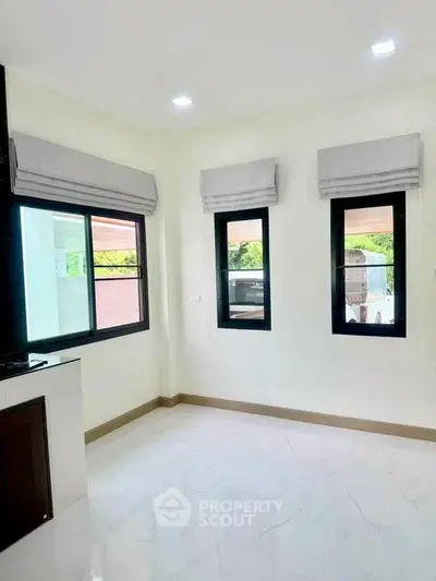 Bright and airy room with large windows and modern finishes, perfect for a cozy living space.