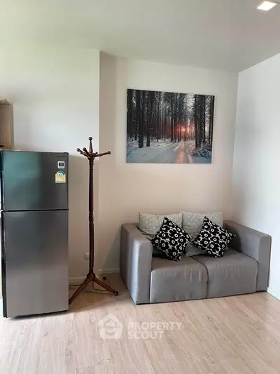 Cozy living room with modern fridge and stylish decor in a contemporary apartment.